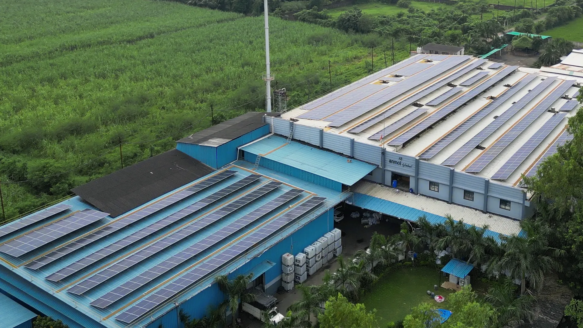 Extensive rooftop solar panel project at Ratnaveer Engineering Precision Ltd surrounded by farmland.