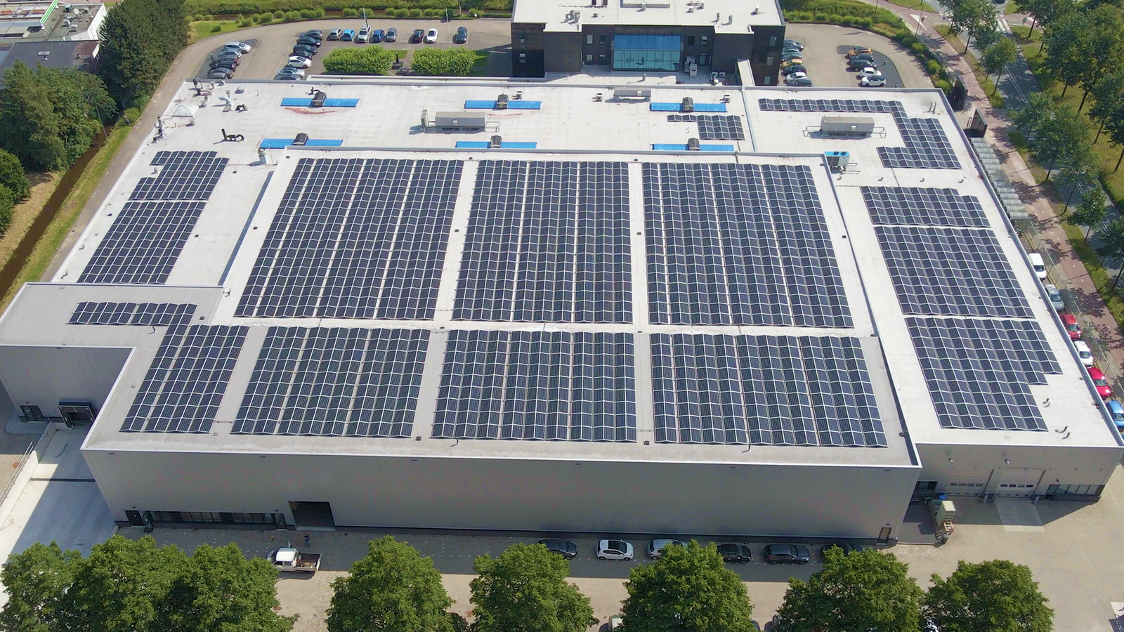 Extensive rooftop solar panel project at Ratnaveer Engineering Precision Ltd surrounded by farmland.