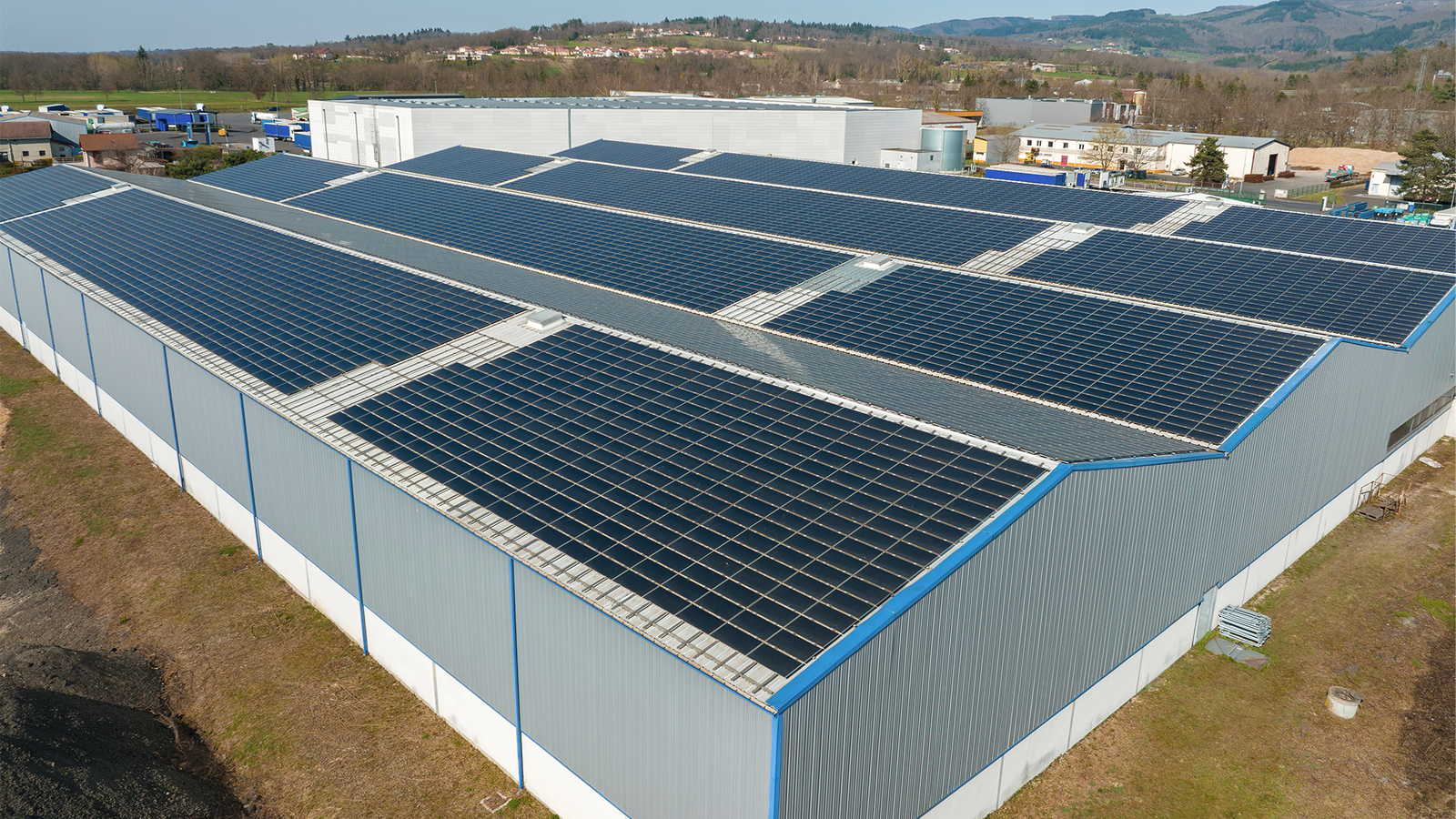 Extensive rooftop solar panel project at Ratnaveer Engineering Precision Ltd surrounded by farmland.